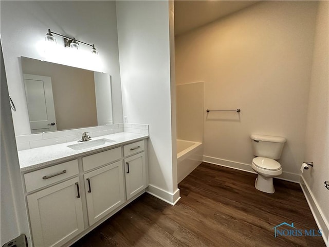 bathroom featuring wood-type flooring, toilet, and vanity