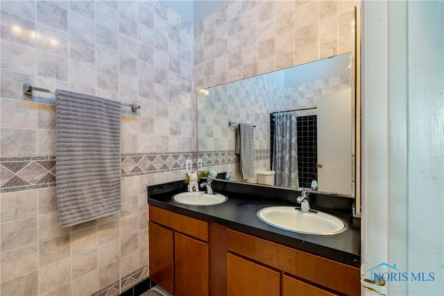 bathroom featuring vanity, tile walls, toilet, and curtained shower