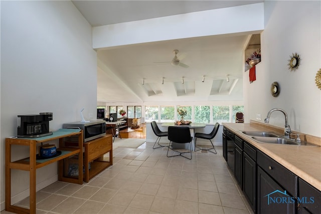 kitchen with light tile patterned floors, dishwasher, sink, ceiling fan, and vaulted ceiling with beams