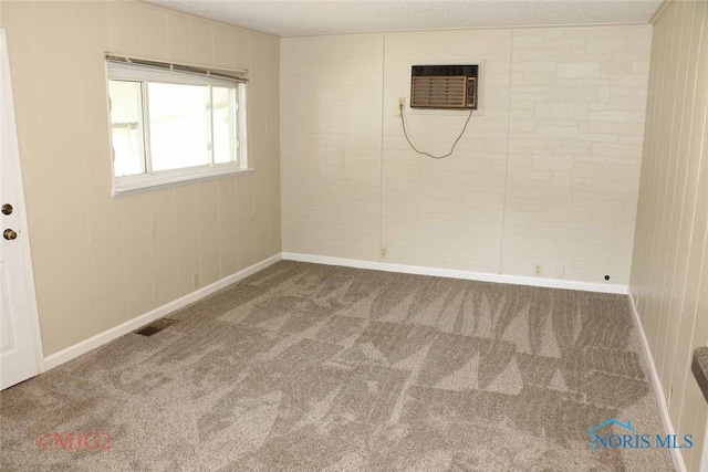 empty room featuring a wall unit AC and carpet flooring