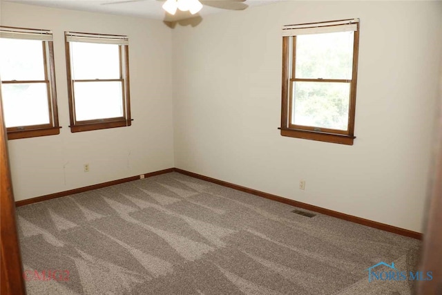 carpeted spare room with ceiling fan