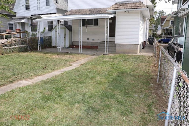 back of house featuring a storage unit and a yard