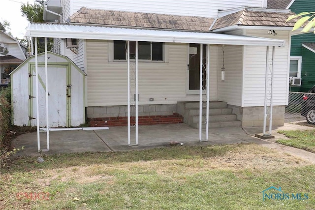 rear view of property featuring a storage unit and a patio