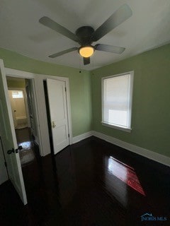 unfurnished bedroom featuring ceiling fan and dark hardwood / wood-style flooring