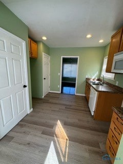 kitchen featuring light hardwood / wood-style flooring, sink, white appliances, and a healthy amount of sunlight