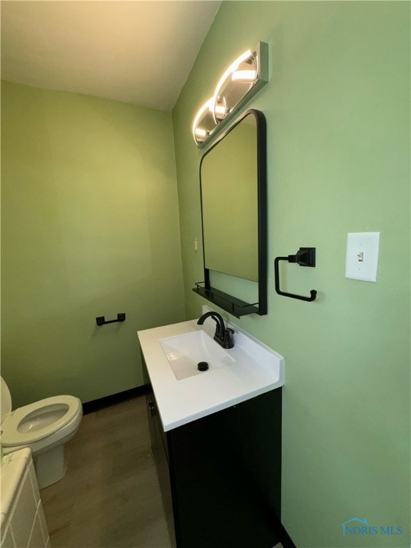 bathroom featuring wood-type flooring, vanity, and toilet