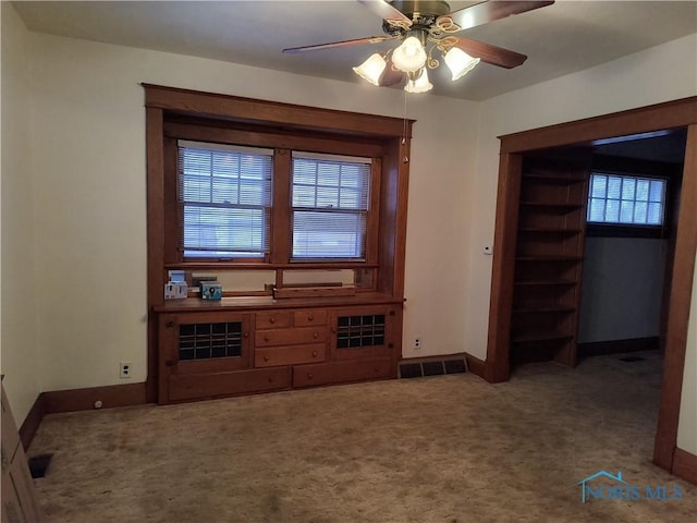 carpeted living room with ceiling fan and plenty of natural light