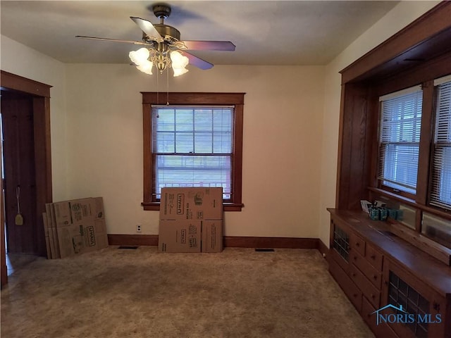 spare room with ceiling fan and carpet