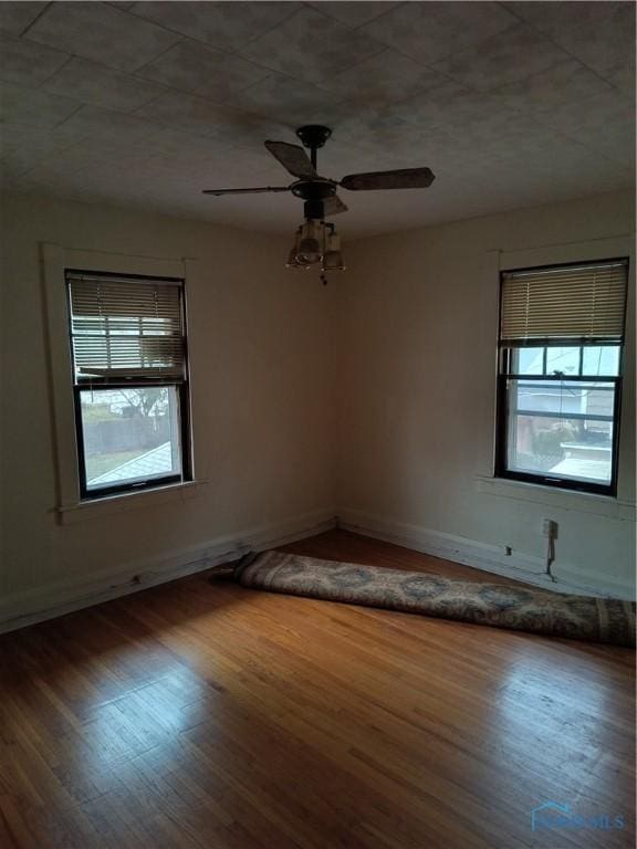 empty room with ceiling fan and wood-type flooring