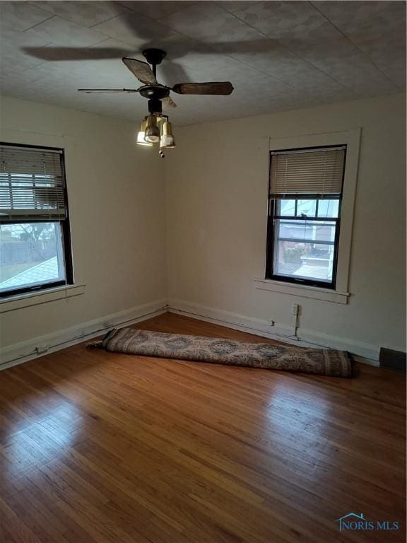 empty room with hardwood / wood-style flooring and ceiling fan