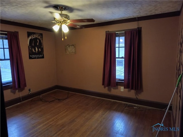 empty room featuring ceiling fan, crown molding, and hardwood / wood-style flooring