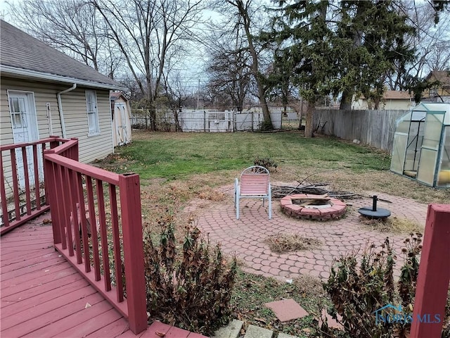 view of yard with a deck, an outdoor structure, and an outdoor fire pit