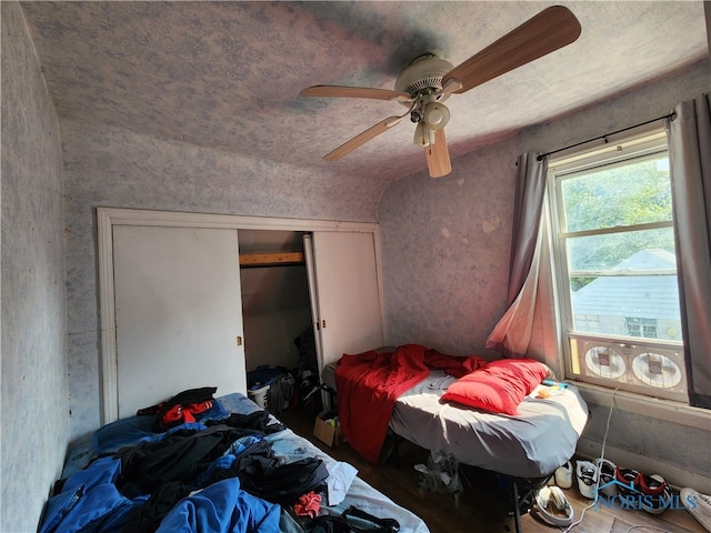 bedroom featuring lofted ceiling, ceiling fan, and a closet