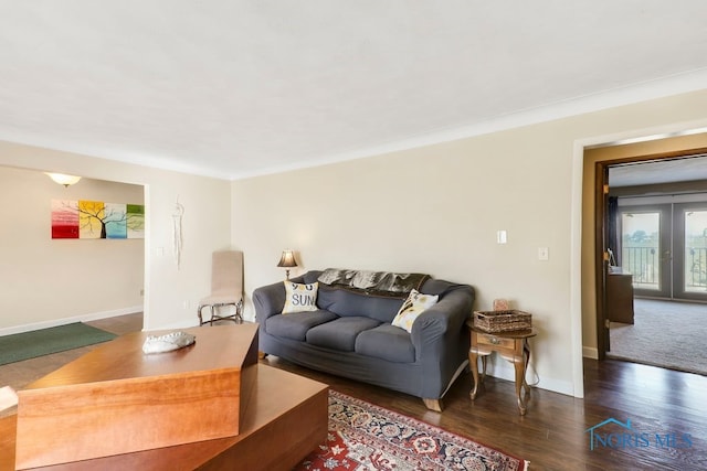 living room featuring dark wood-type flooring and ornamental molding