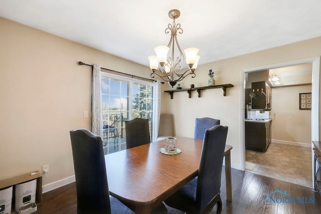 dining space with dark hardwood / wood-style floors and an inviting chandelier