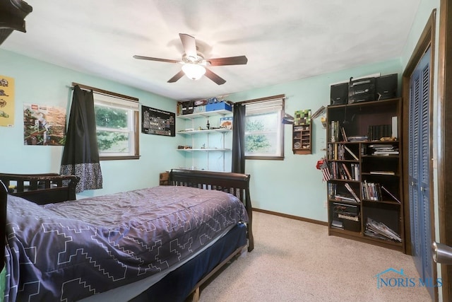 bedroom featuring carpet, ceiling fan, multiple windows, and a closet