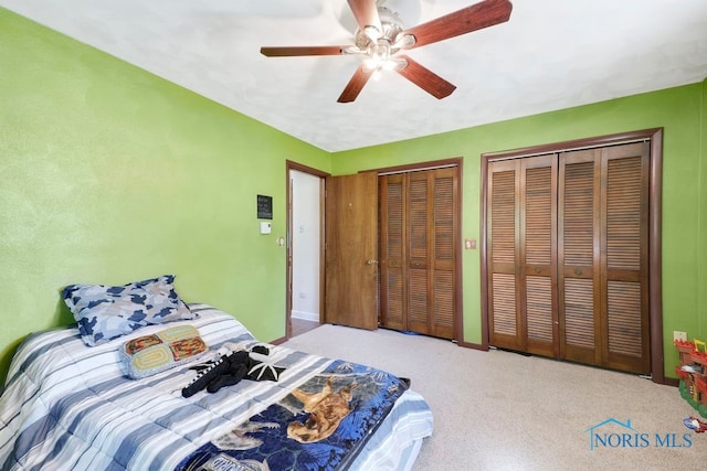 bedroom featuring ceiling fan and multiple closets