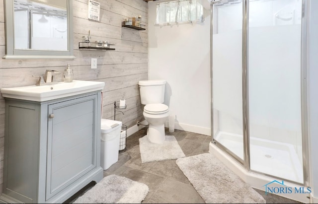 bathroom with vanity, toilet, walk in shower, and wooden walls