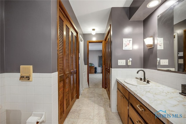 bathroom with vanity and tile walls