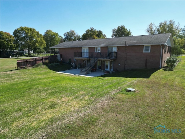 rear view of house featuring a lawn, a patio area, and a wooden deck