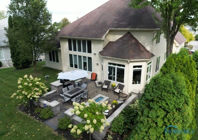 back of property with outdoor lounge area, a lawn, and a patio