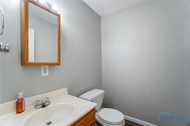 bathroom with vanity, a textured ceiling, and toilet