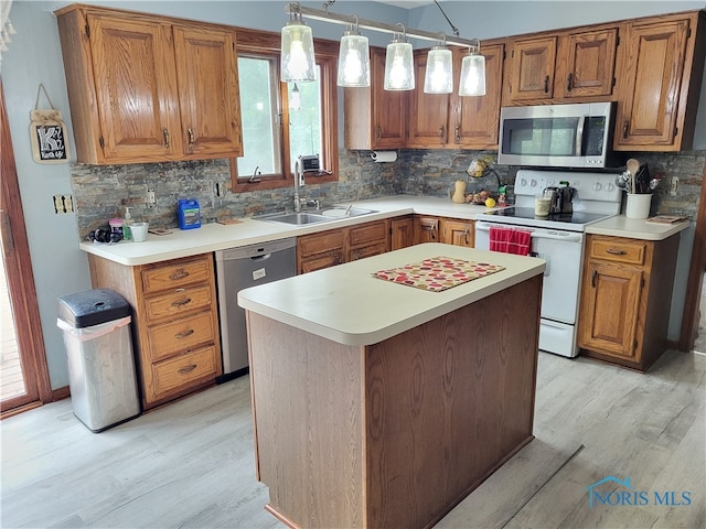 kitchen featuring backsplash, stainless steel appliances, hanging light fixtures, and sink