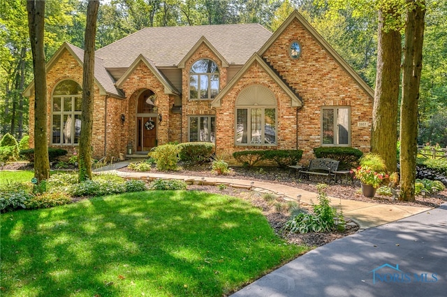 tudor-style house with a front lawn