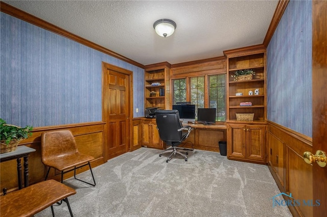 home office with a textured ceiling, light colored carpet, and crown molding