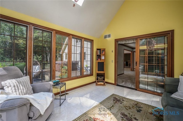 doorway featuring light tile patterned floors and high vaulted ceiling