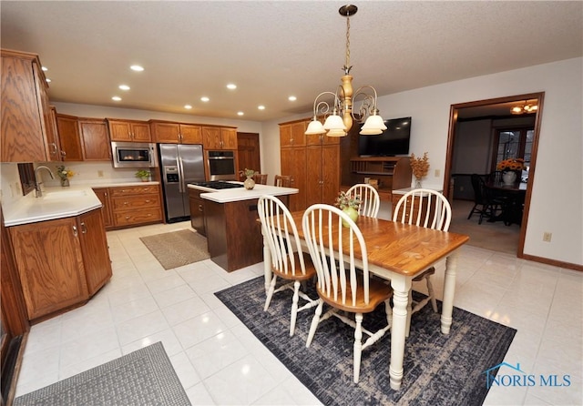 tiled dining area with sink and an inviting chandelier