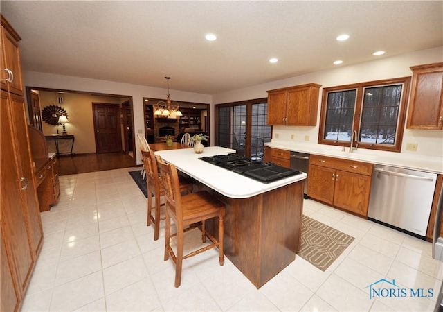 kitchen with a kitchen bar, pendant lighting, a notable chandelier, dishwasher, and a center island