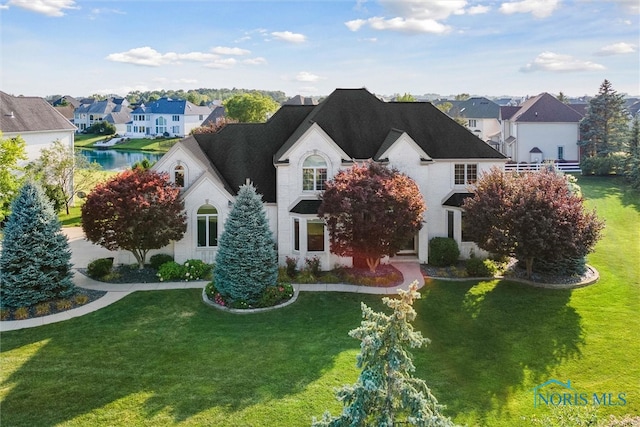 french country inspired facade featuring a front lawn