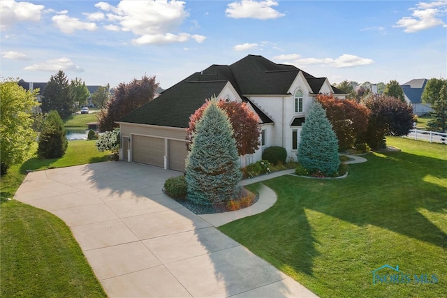 view of front facade featuring a front yard, a water view, and a garage