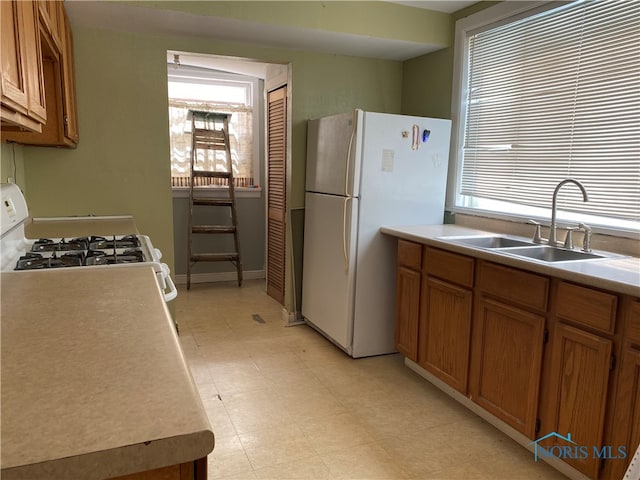 kitchen featuring white appliances and sink