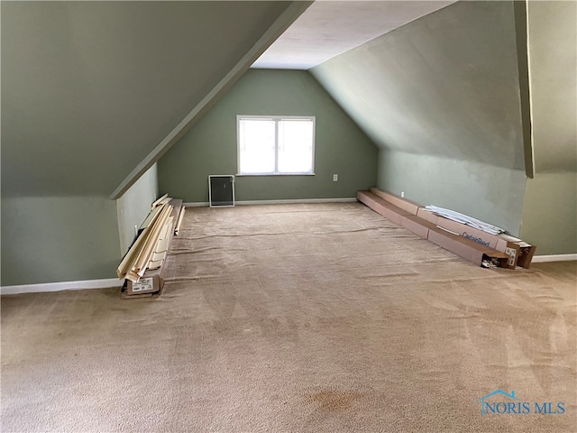 additional living space with vaulted ceiling and light colored carpet