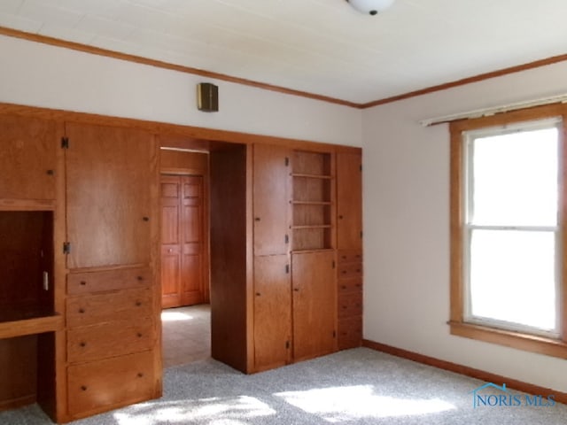 unfurnished bedroom with a closet, crown molding, and light carpet