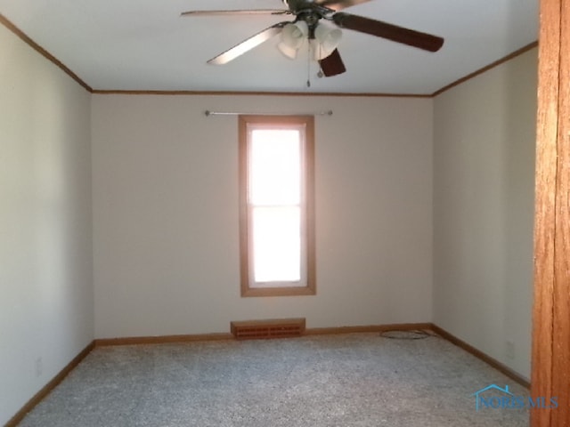 carpeted empty room with ceiling fan and crown molding