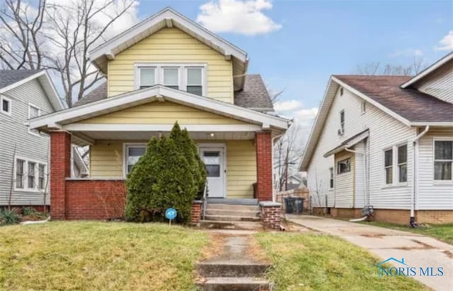 bungalow-style home featuring a front yard and covered porch