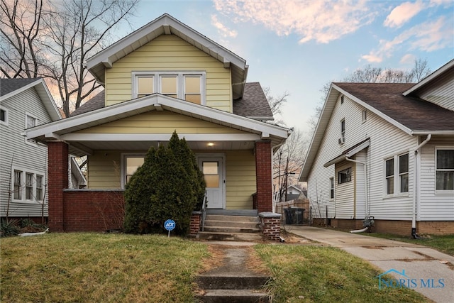 bungalow-style home with a front lawn and a porch