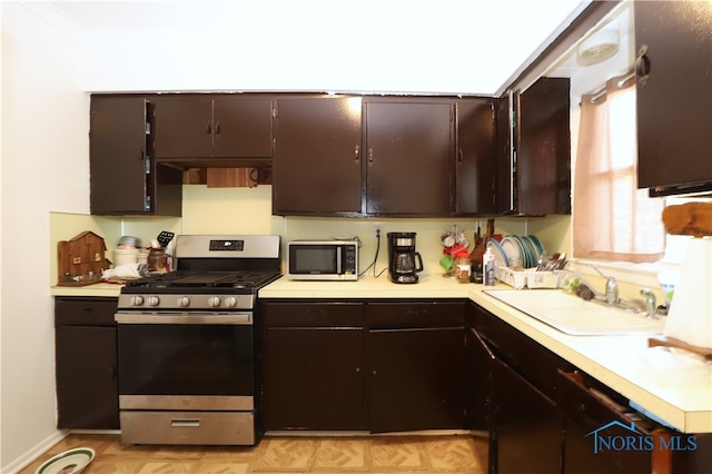 kitchen featuring stainless steel appliances, sink, and dark brown cabinetry