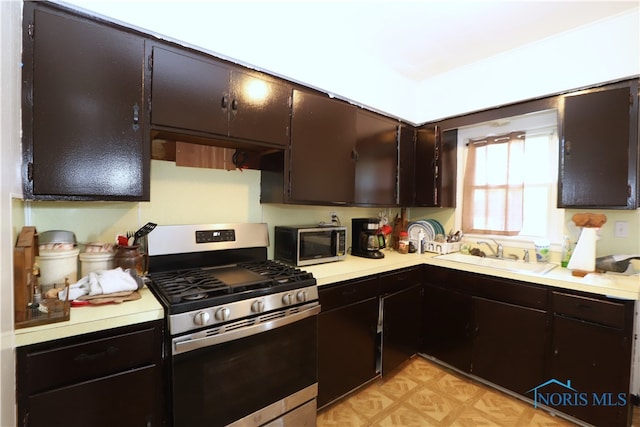 kitchen featuring stainless steel appliances, sink, and dark brown cabinetry