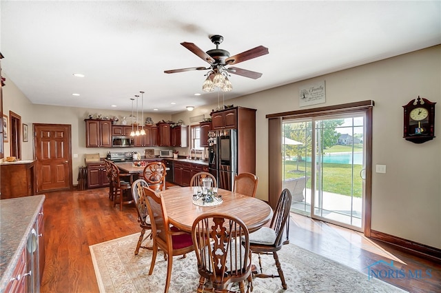 dining area featuring dark hardwood / wood-style flooring, sink, and ceiling fan