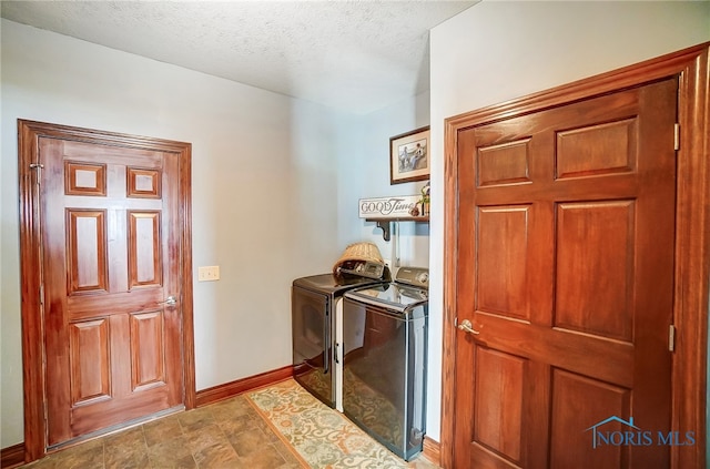 laundry area with a textured ceiling and washer and dryer