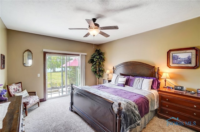 carpeted bedroom with a textured ceiling, access to outside, and ceiling fan