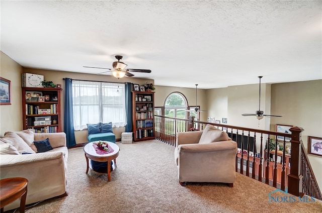 carpeted living room with ceiling fan and a textured ceiling