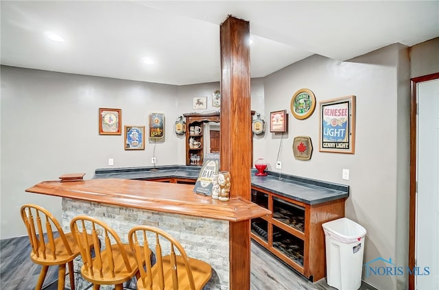 bar featuring butcher block countertops and light hardwood / wood-style floors