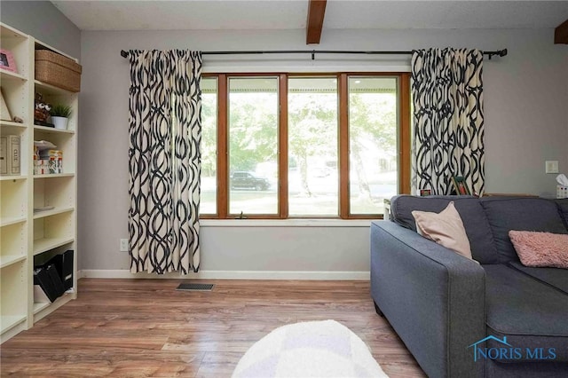 living room with hardwood / wood-style floors and beam ceiling