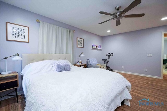 bedroom with dark hardwood / wood-style flooring and ceiling fan