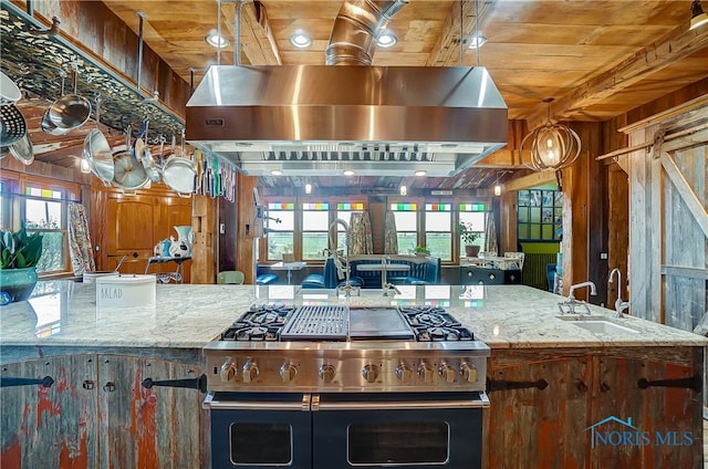 kitchen featuring pendant lighting, double oven range, sink, light stone countertops, and wood ceiling